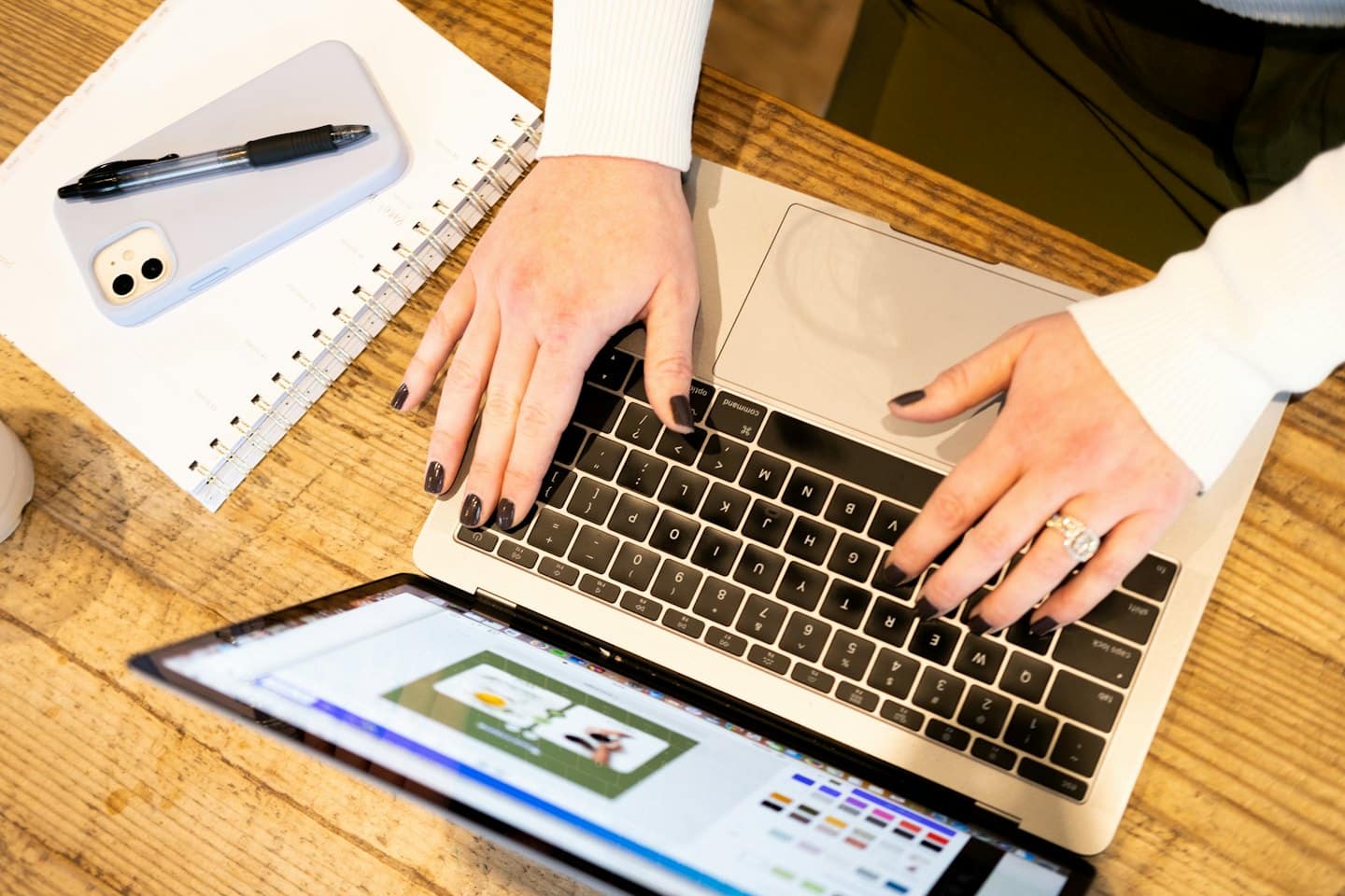 Person types on a laptop with a design interface open.
